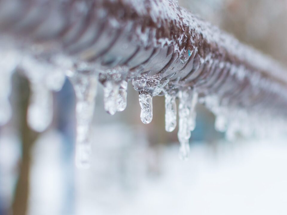 Frozen water pipe covered in ice during winter, showing a common plumbing risk and the importance of preventing frozen pipes